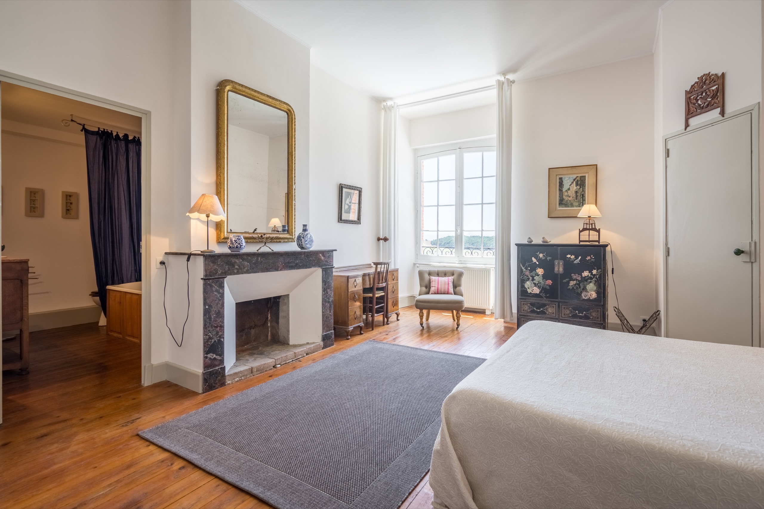 Vue principale de la Chambre des Oiseaux avec lit double, cheminée en marbre et grande fenêtre sur le parc