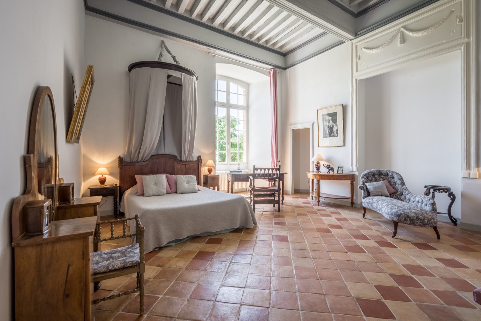 Vue principale de la Chambre du Parc avec lit à baldaquin, miroir ancien et grande fenêtre sur le parc