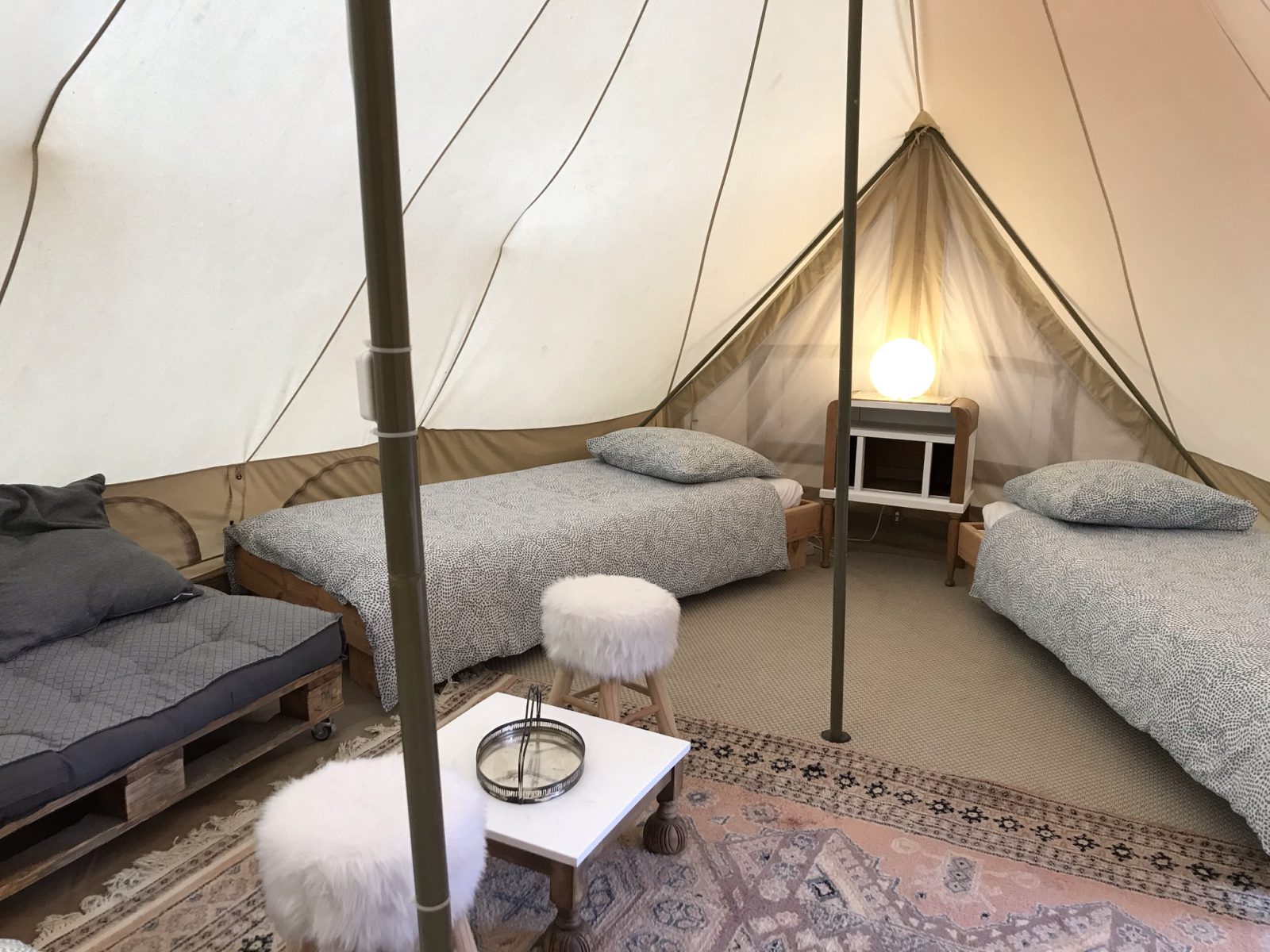 Intérieur du lodge Jasmin avec deux lits simples, tapis clair et mobilier discret